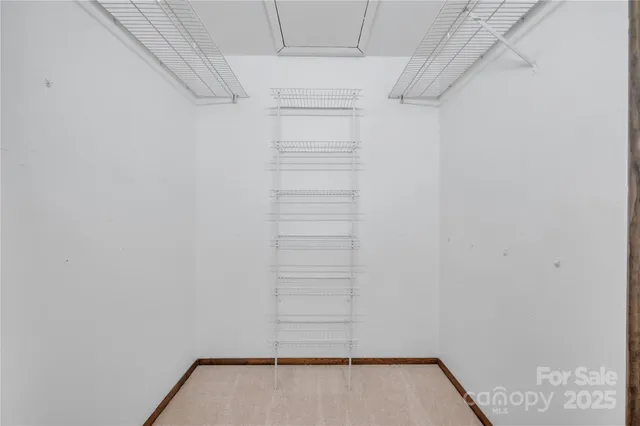 a view of walk in closet with empty racks