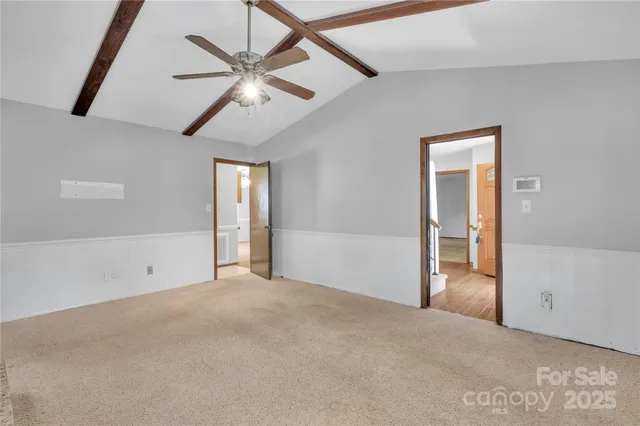 en empty room with ceiling fan and window
