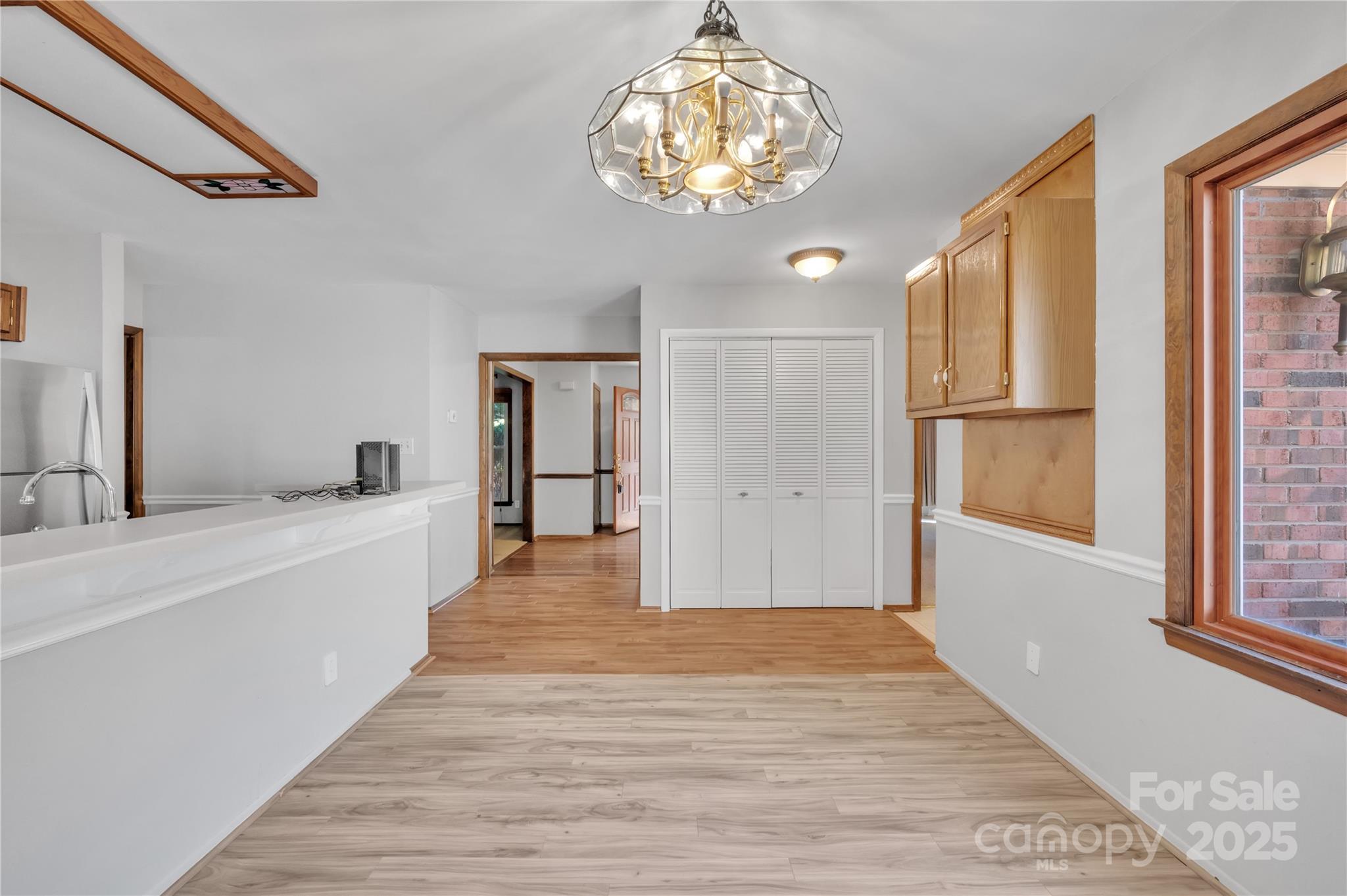 702 Trail Ridge Road Matthews, NC 28105 - Photo 8 of 36 a large white kitchen with wooden floor and chandelier