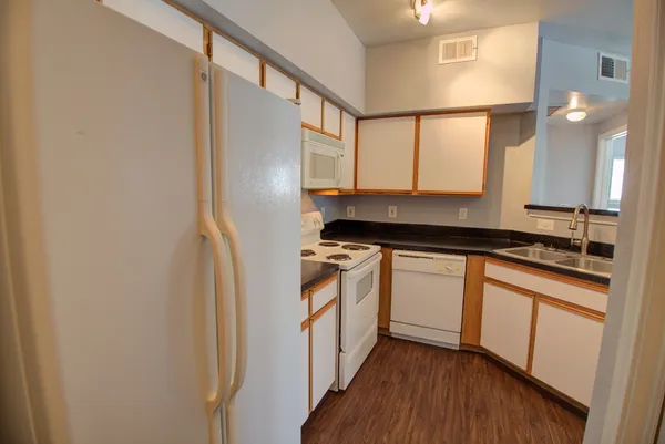 a kitchen with stainless steel appliances granite countertop a stove a sink and a refrigerator