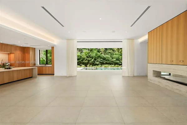 a large white kitchen with a refrigerator a sink and a large window