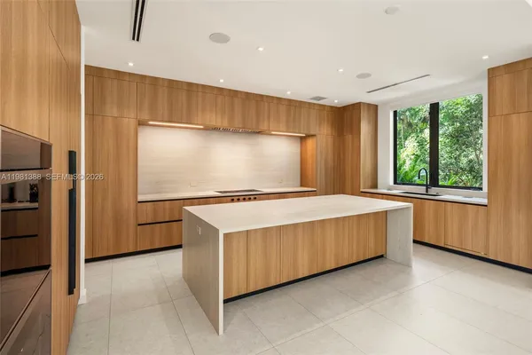 a large white kitchen with a large window