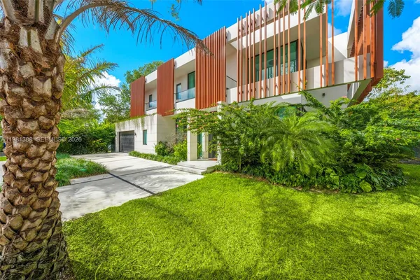 a view of a house with a yard and tree s