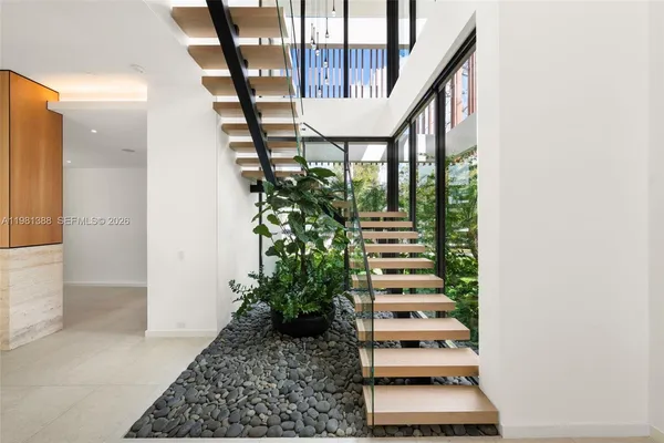 a view of a room with large windows and plants