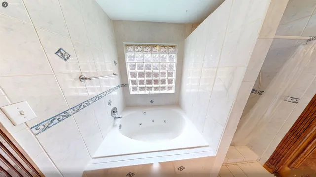 a bathroom with a bathtub and a window