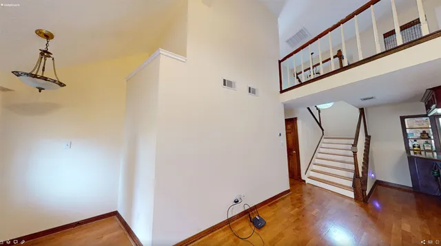 a view of a hallway with wooden floor and stairs