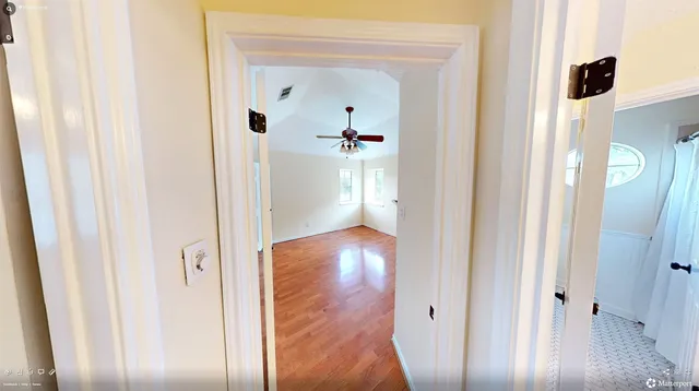 a view of a room with a ceiling fan and a window