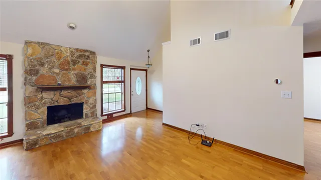 a view of an empty room with window and fire place