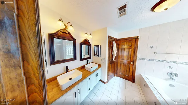 a bathroom with a tub sink and mirror