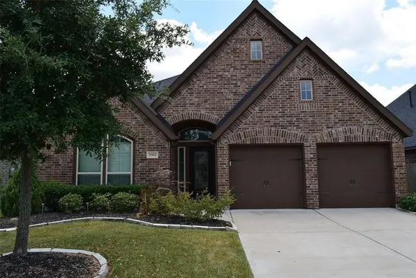 a front view of a house with a garden and plants