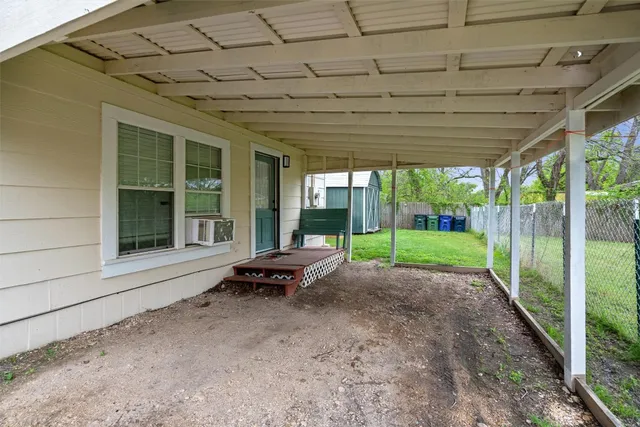 a view of a backyard with wooden floor and fence