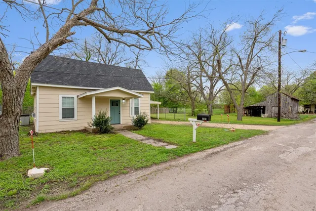 a view of a house with a yard and tree s