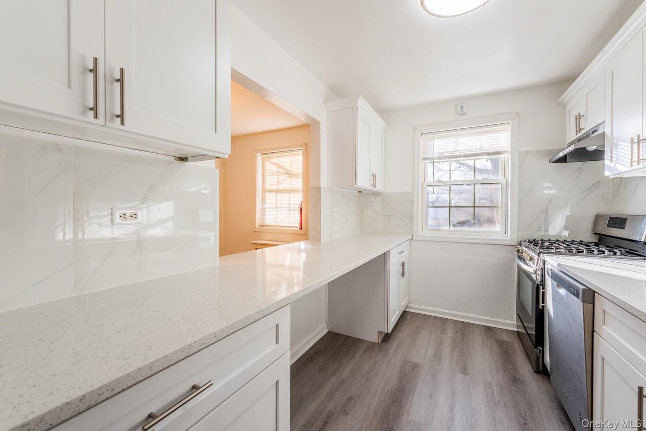 222-17 69th Avenue, Unit 17A Queens, NY 11364 - Photo 8 of 10 a kitchen with granite countertop white cabinets and white appliances