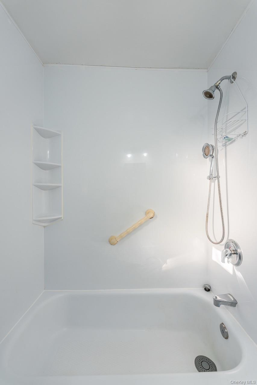 222-17 69th Avenue, Unit 17A Queens, NY 11364 - Photo 9 of 10 a bathroom with a bath tub with a shower