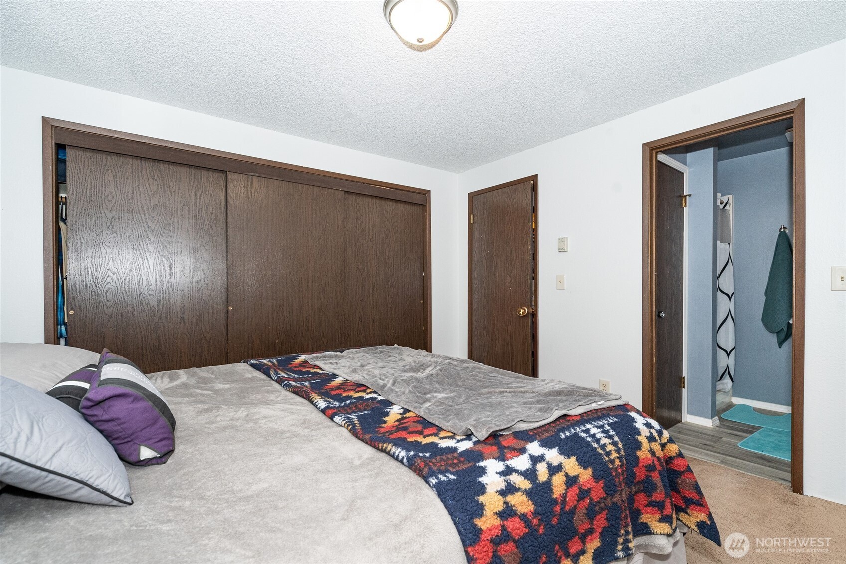 2119 Southwest Olympic Drive Chehalis, WA 98532 - Photo 18 of 33 a bedroom with a large bed and a chandelier