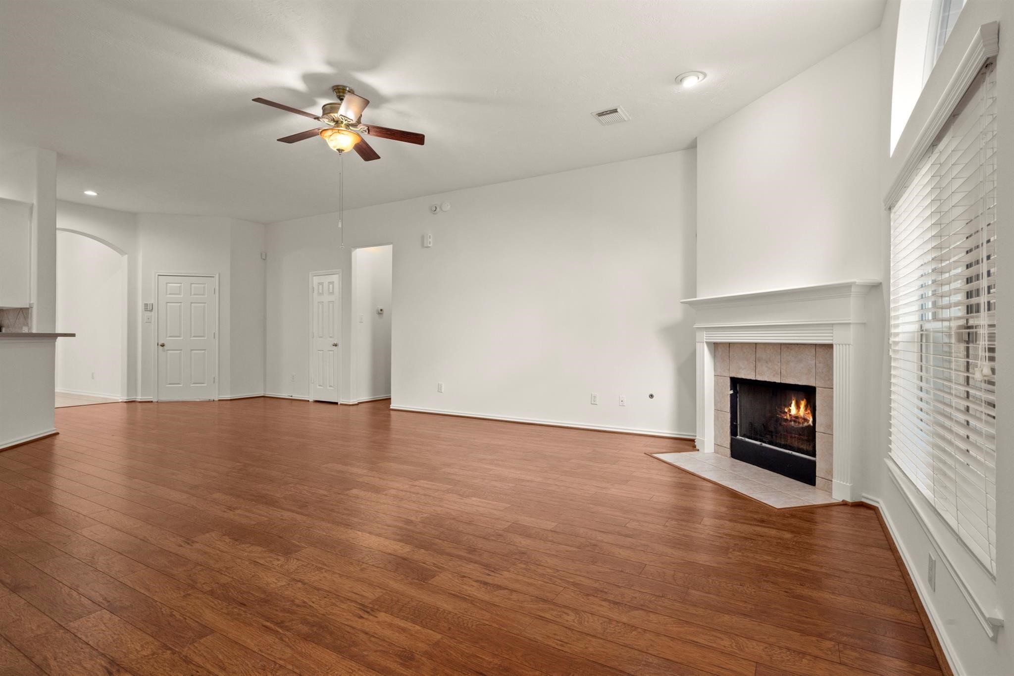 21014 Jessica Rose Lane Spring, TX 77379 - Photo 8 of 30 a view of an empty room with wooden floor fireplace and a window