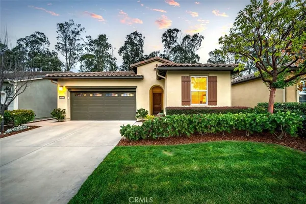 a front view of a house with a garden and plants