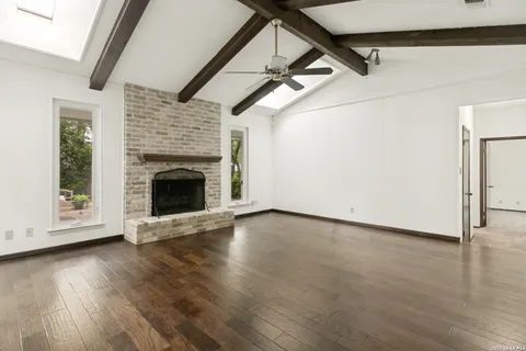a view of empty room with wooden floor and fireplace