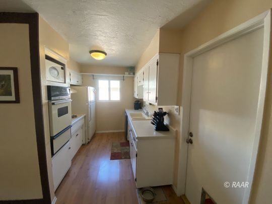413 Karin Street Ridgecrest, CA 93555 - Photo 6 of 20 a kitchen with cabinets and wooden floor