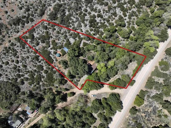 an aerial view of residential house with outdoor space and trees all around
