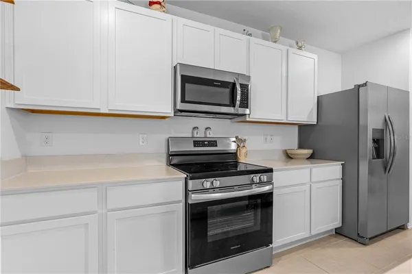 a kitchen with stainless steel appliances white cabinets and a stove a refrigerator with wooden floors