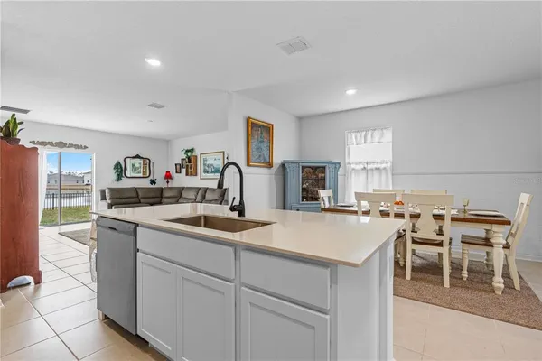 a kitchen with a sink and chairs