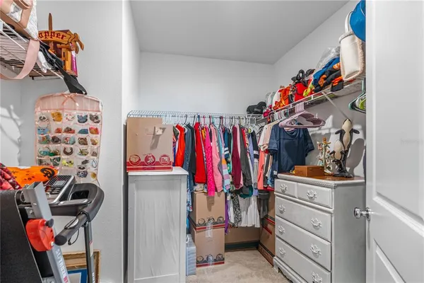 a view of walk in closet with clothes and shoes