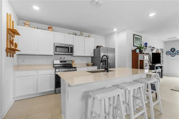 a kitchen with stainless steel appliances granite countertop a refrigerator sink stove microwave and cabinets