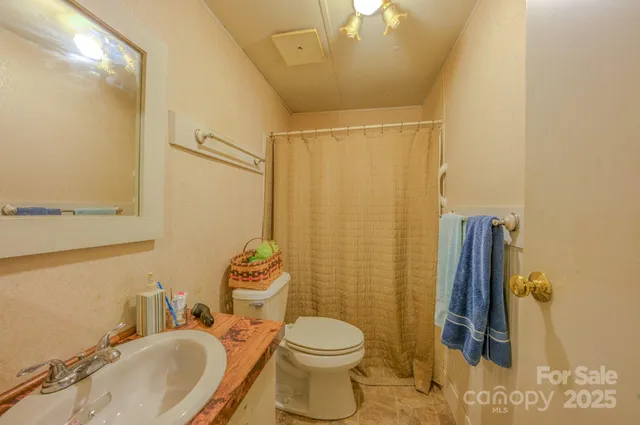 a bathroom with a sink mirror vanity and toilet