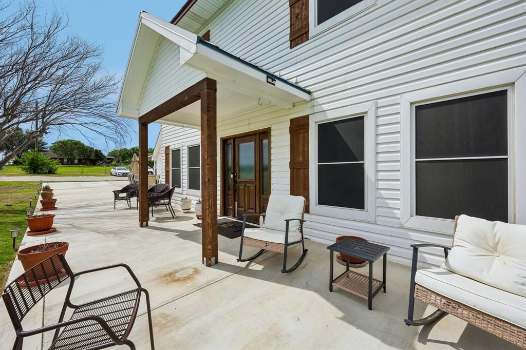 331 Radecke Road Krum, TX 76249 - Photo 5 of 40 Spacious concrete front porch featuring a covered entry with exposed wood-finish support beams