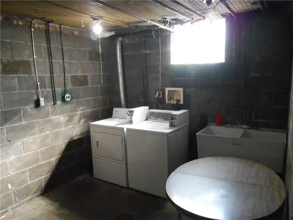 a view of a storage room with water heater and a sink