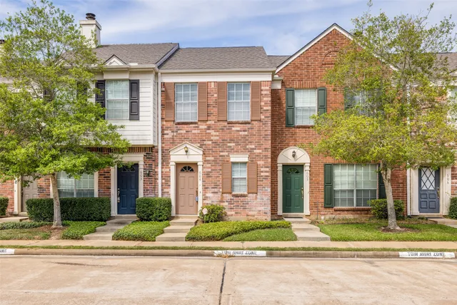 front view of a brick house with a yard