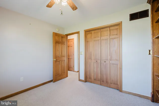 an empty room with window and fan