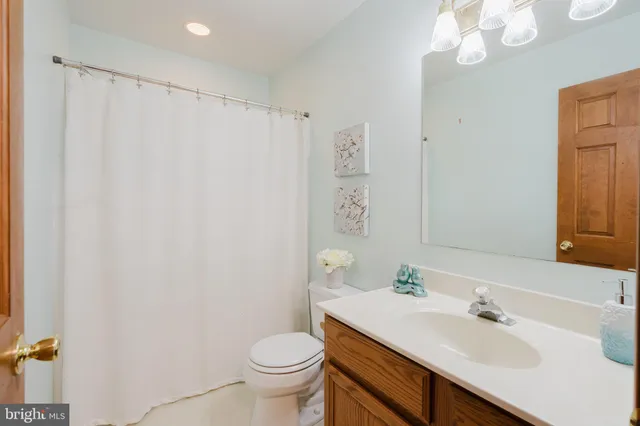 a bathroom with a granite countertop sink a toilet and a mirror