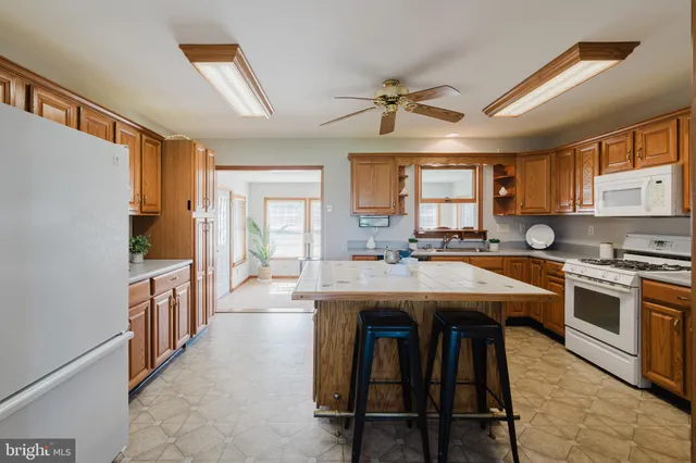 a kitchen with granite countertop a sink appliances a counter space and a window