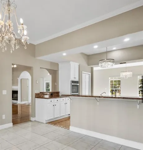 a large white kitchen with kitchen island a sink stainless steel appliances and cabinets