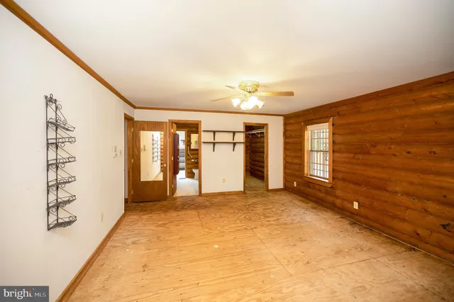 an empty room with windows and a ceiling fan