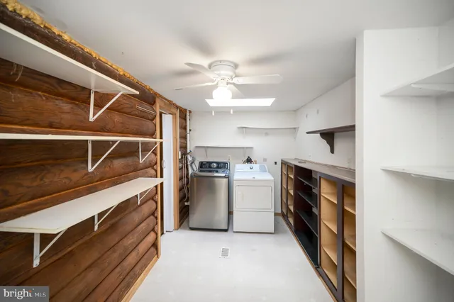 an empty room with windows and ceiling fan