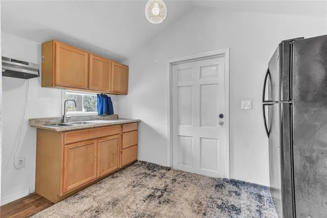 a kitchen with stainless steel appliances granite countertop a refrigerator and a sink