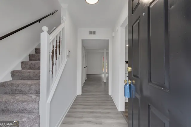 a view of a hallway with wooden floor and entryway