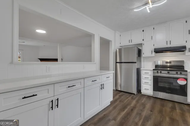 a kitchen with refrigerator a stove and a wooden cabinets