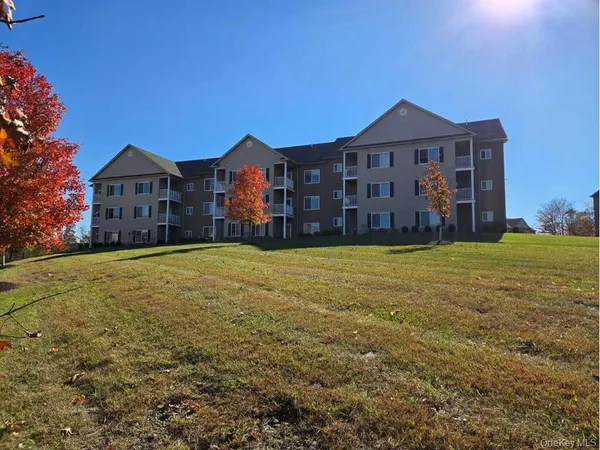 a view of a large house with a big yard and large trees