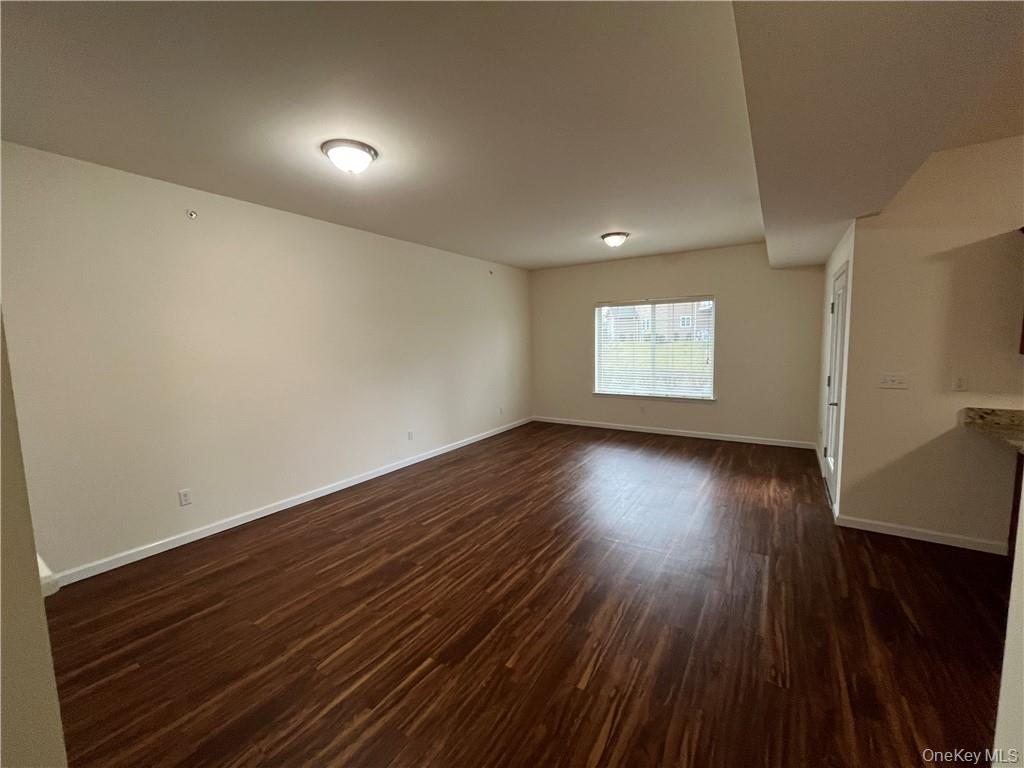 44 High Street, Unit 325 Chester, NY 10918 - Photo 6 of 16 a view of an empty room with wooden floor and a window