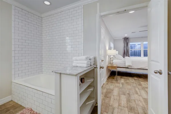a bathroom with a granite countertop sink and a bathtub