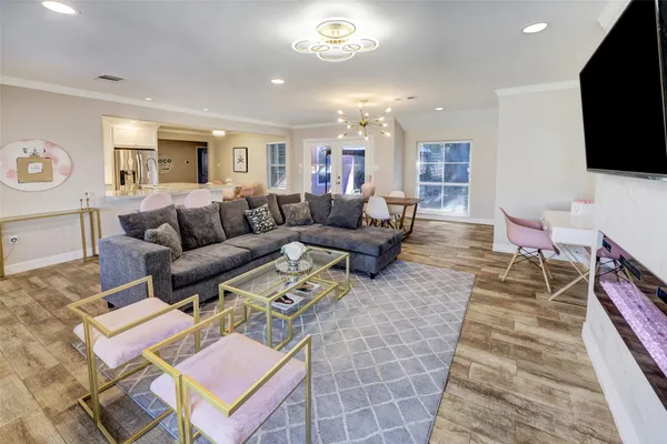 a living room with furniture a flat screen tv and a table
