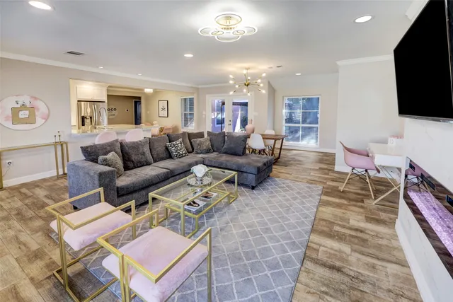 a living room with furniture a flat screen tv and a table