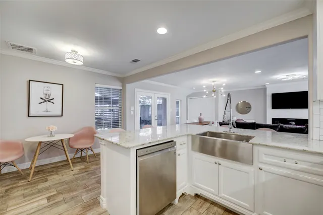 a kitchen with white cabinets and chairs