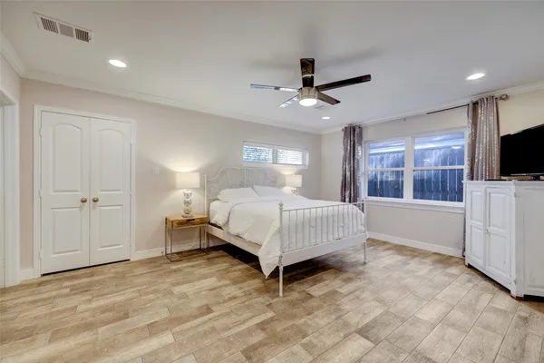 a bedroom with a bed flat screen tv and a window