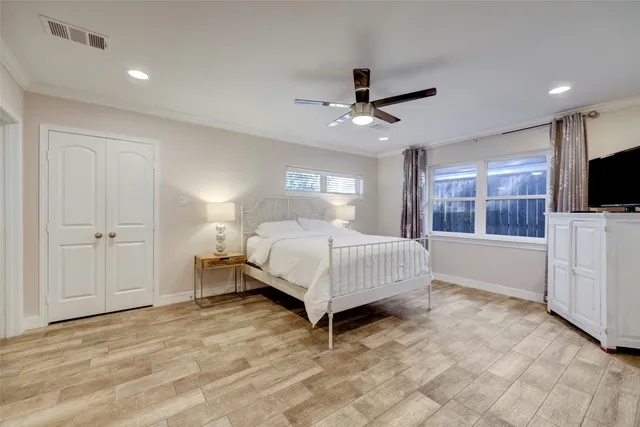 a bedroom with a bed flat screen tv and a window