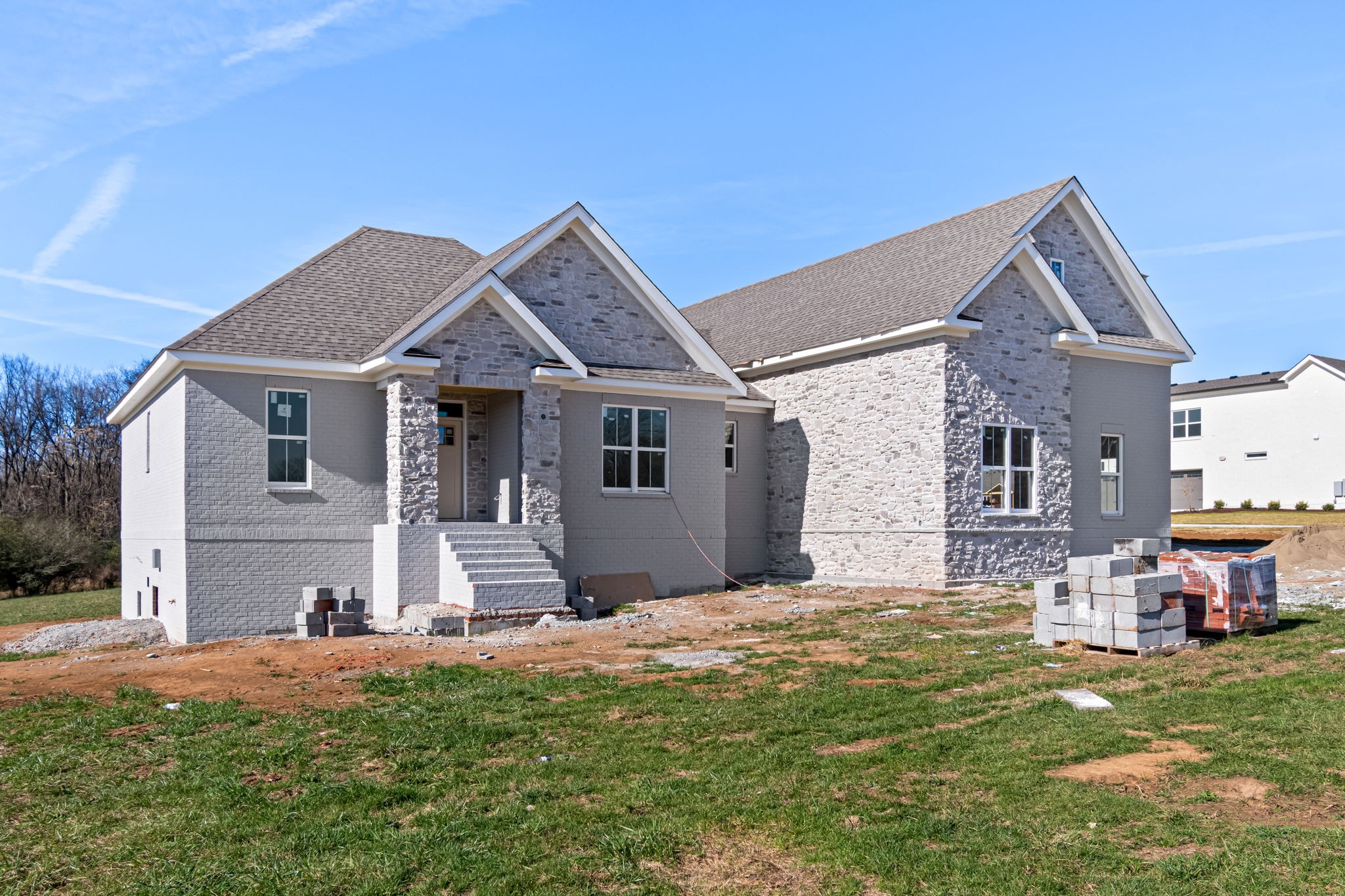 a front view of a house with a garden and yard